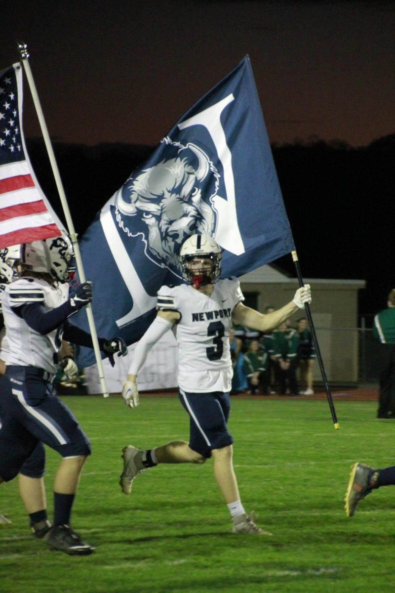 Jordan Vadasz runs the Buffalo flag onto the field at James Buchanan.