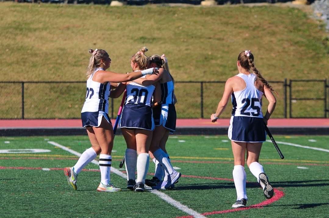 Field hockey girls huddling during a game