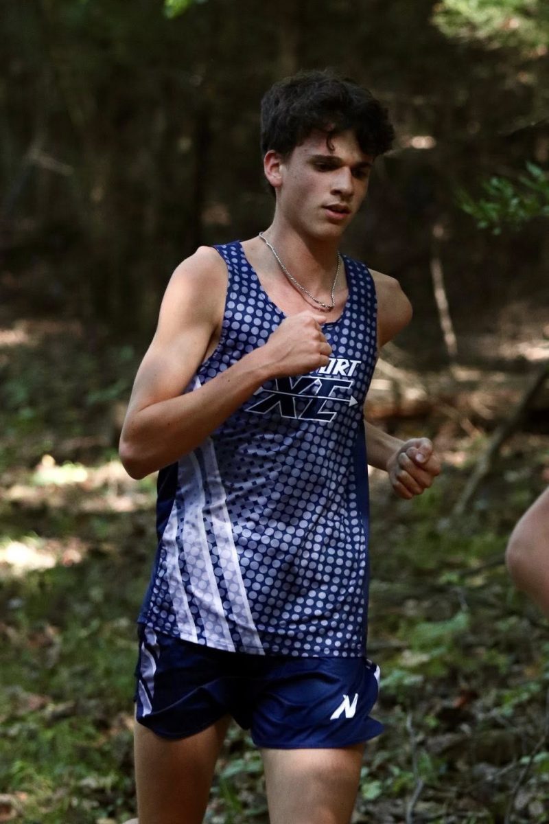 Senior Riley Babski strides past the first mile marker on his home course during a Tri-Valley League meet.