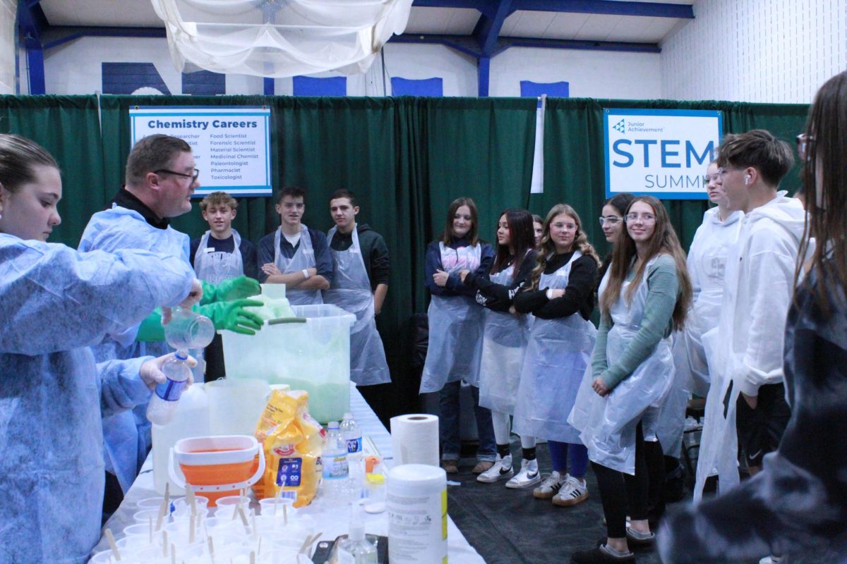 Students at the JA STEM Summit gather around the demonstration of the elephant toothpaste lab. 